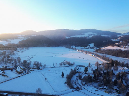 Drohnenaufnahme vom verschneiten Stubenbergsee.